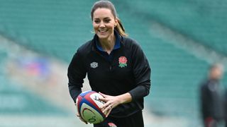 Catherine, Duchess of Cambridge runs with the ball as she takes part in the England's rugby teams training sessions at the Twickenham Stadium