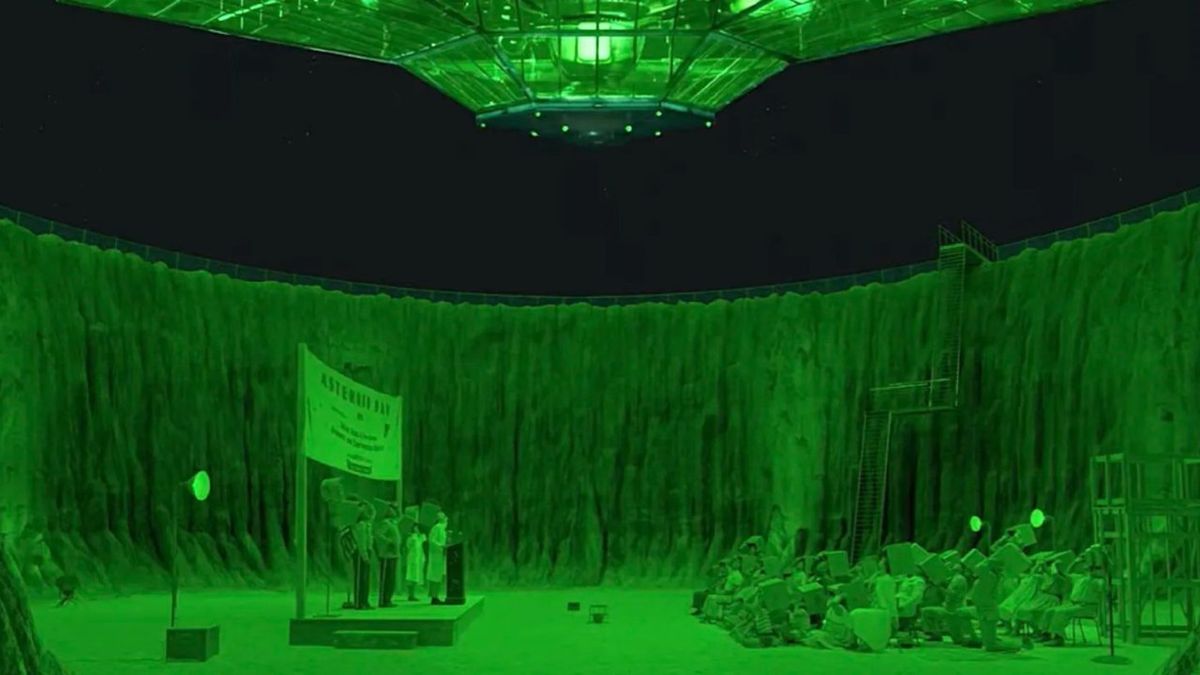 tables and chairs are set up in a crater bathed in green light