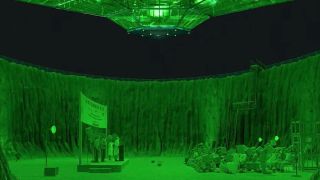 tables and chairs are set up in a crater bathed in green light