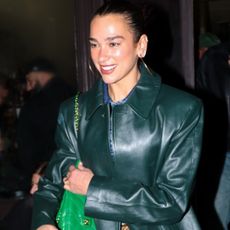 Dua Lipa was spotted in Paris wearing a dark green leather coat, skinny jeans, boots with fur, and a Chanel 25 bag