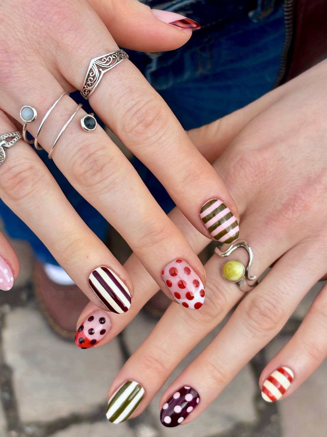 Mismatched striped and polka dot nails.