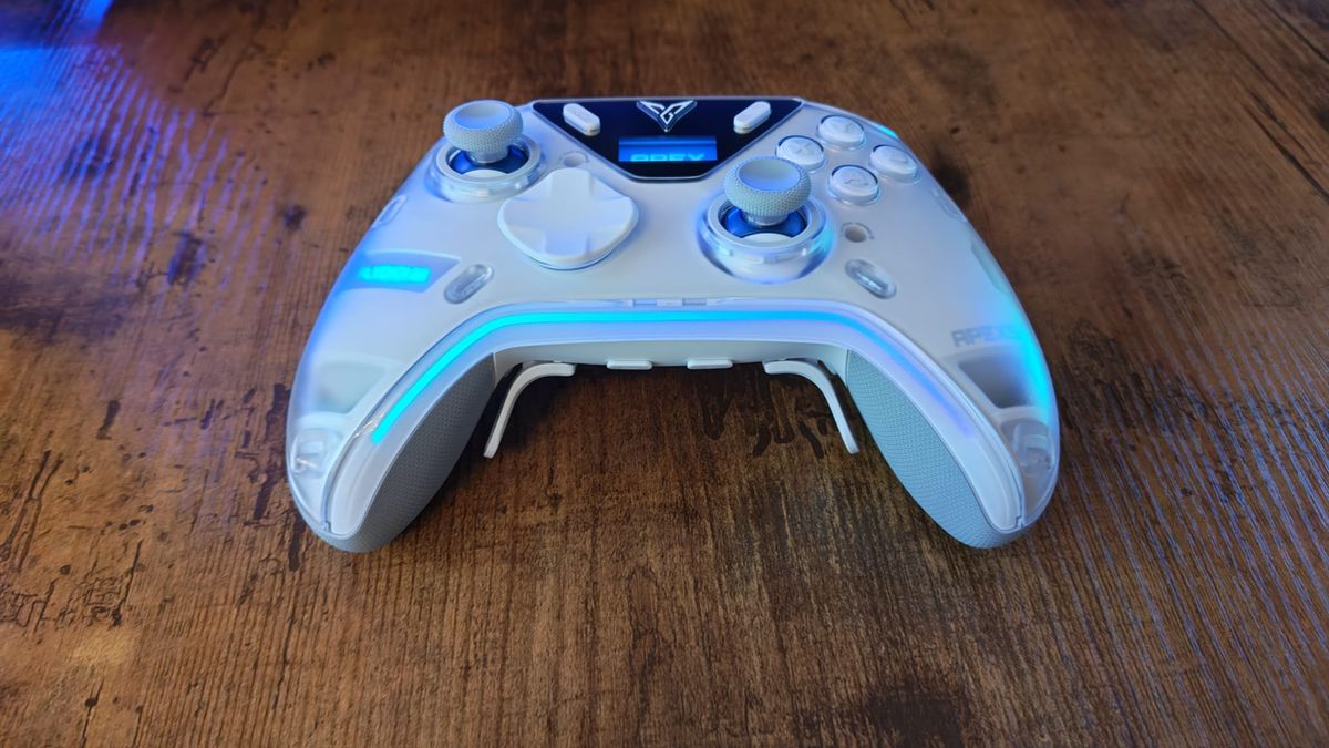 A Flydigi Apex 5 lying on a walnut desktop
