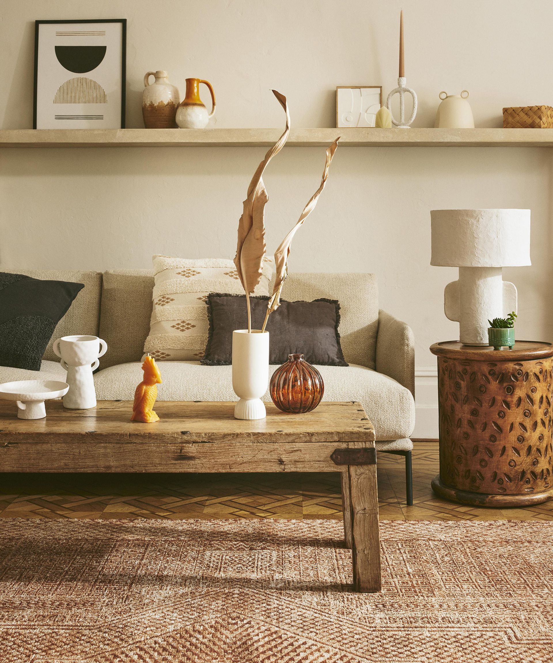 A neutral gallery wall in living room with framed print and sculptural accessories