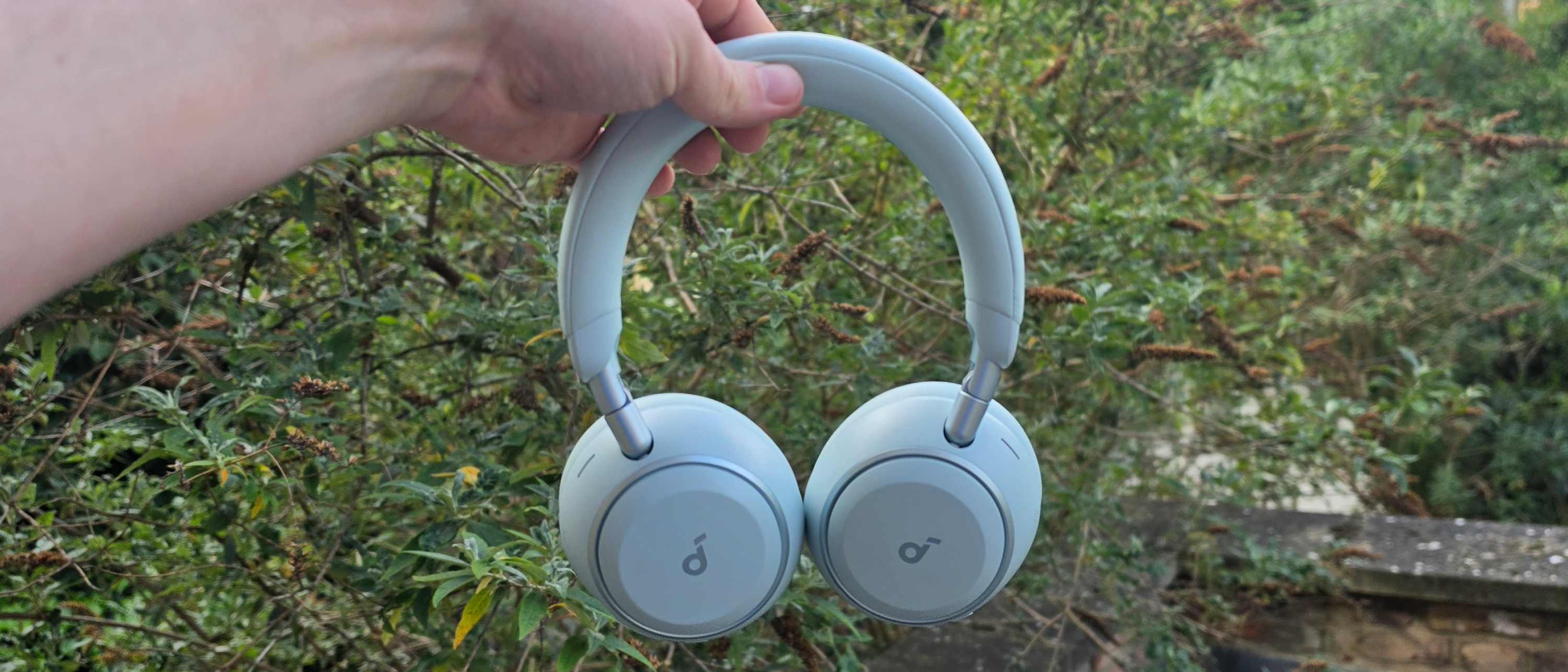 The Soundcore Space 2 in front of a green bush.