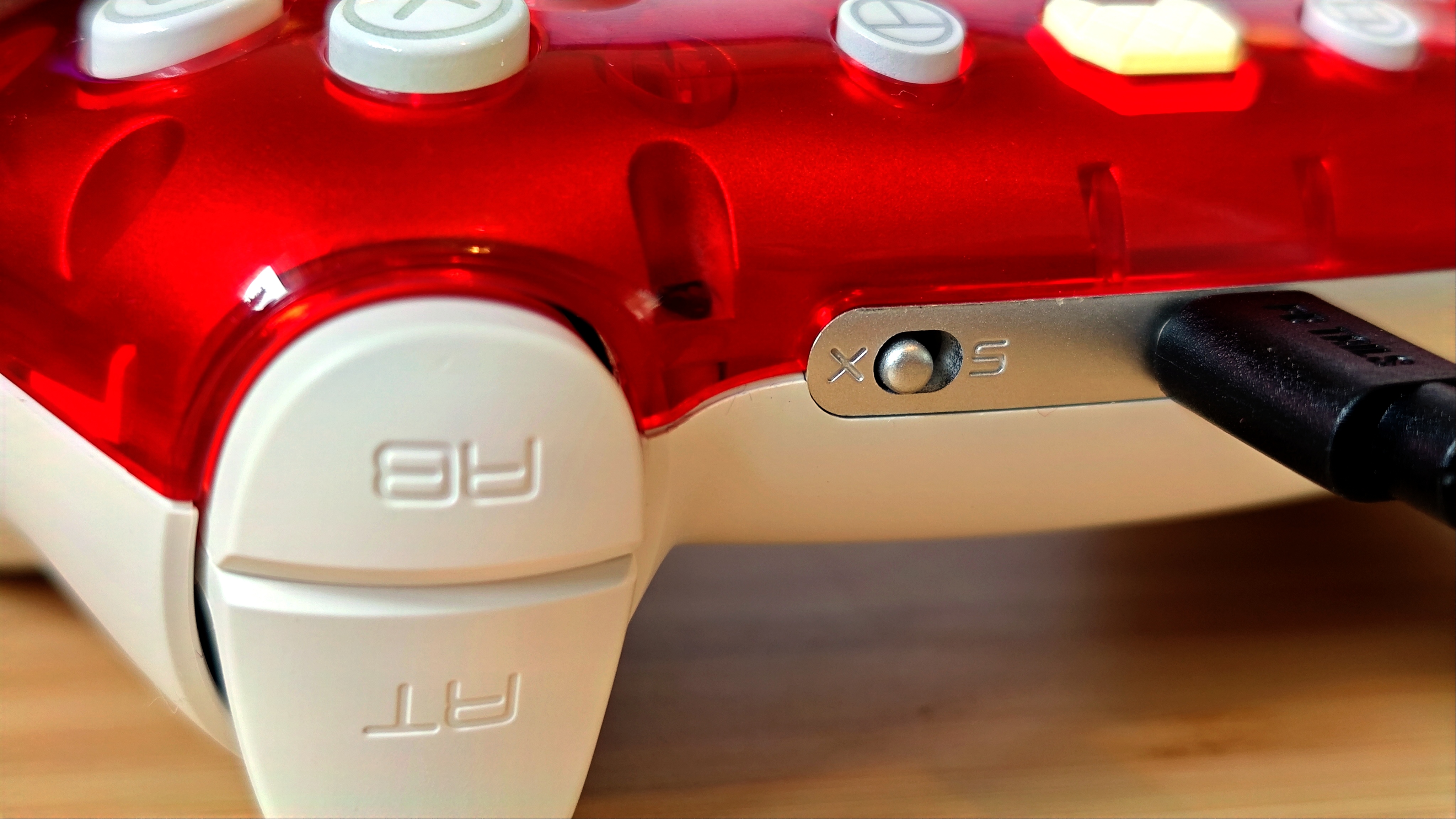 Front view of a Ruby red PB Tails Crush gaming controller sitting on a wooden desk
