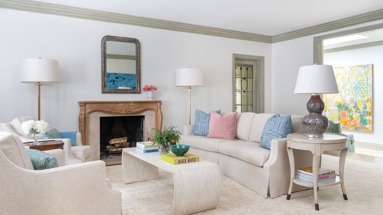 neutral colors in living room with pale sofas and pastel cushions with fireplace and pale carpet