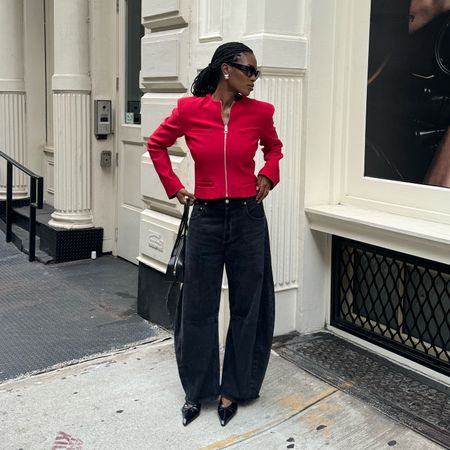 London woman wears a red zip up cardigan, black Citizens of Humanity barrel jeans, pointy toe heels and black sunglasses in New York. 