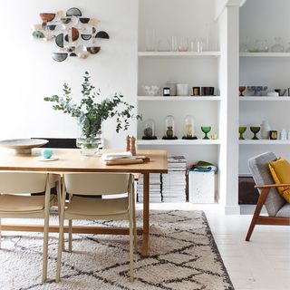 white dining room with table and walled shelves