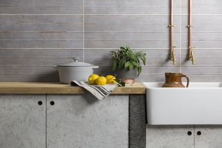 Grey rustic Gemini Tiles as a backsplash in a grey concrete effect kitchen with Belfast/Butler's sink
