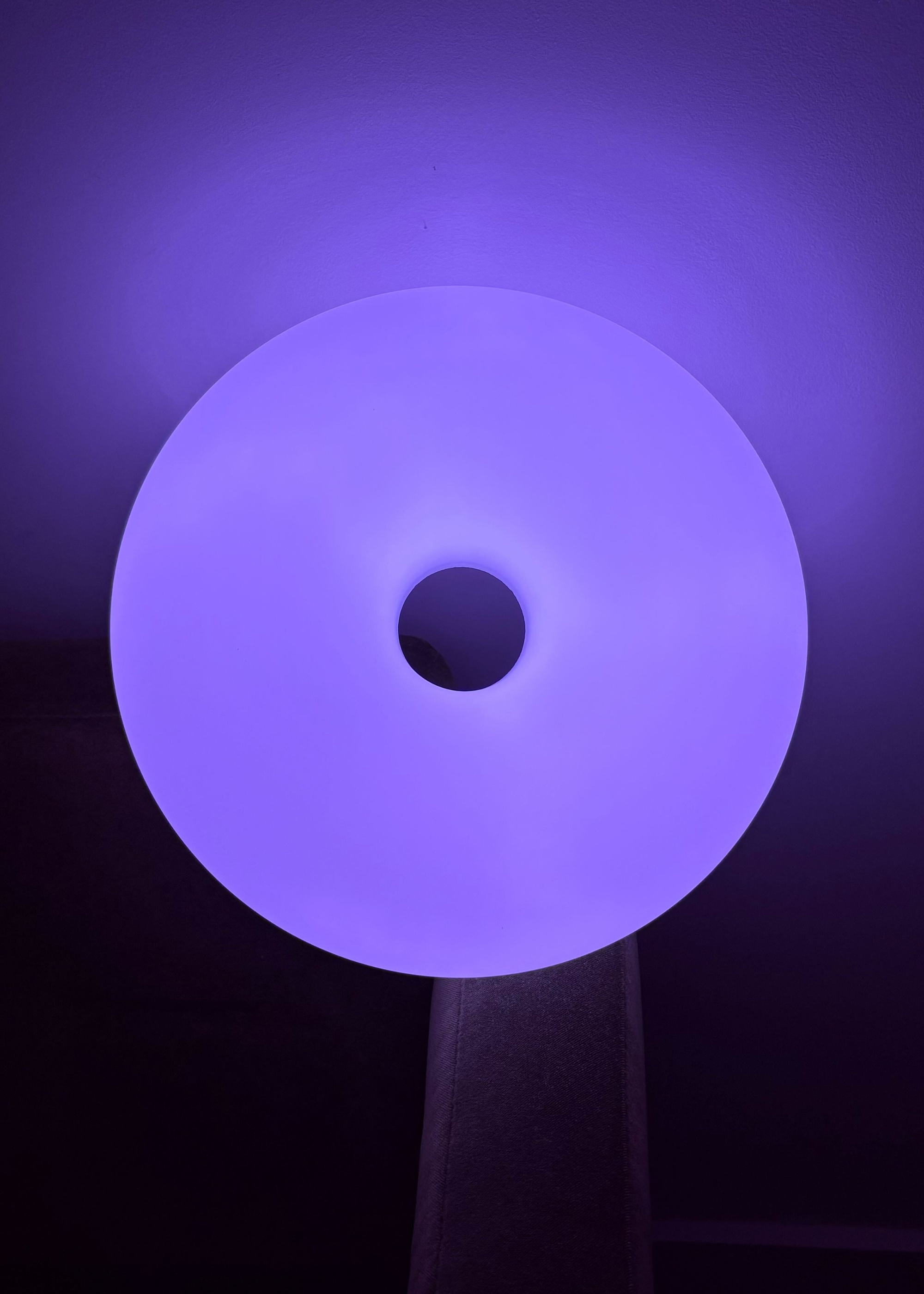 The IKEA VARMBLIXT donut lamp reflecting purple light
