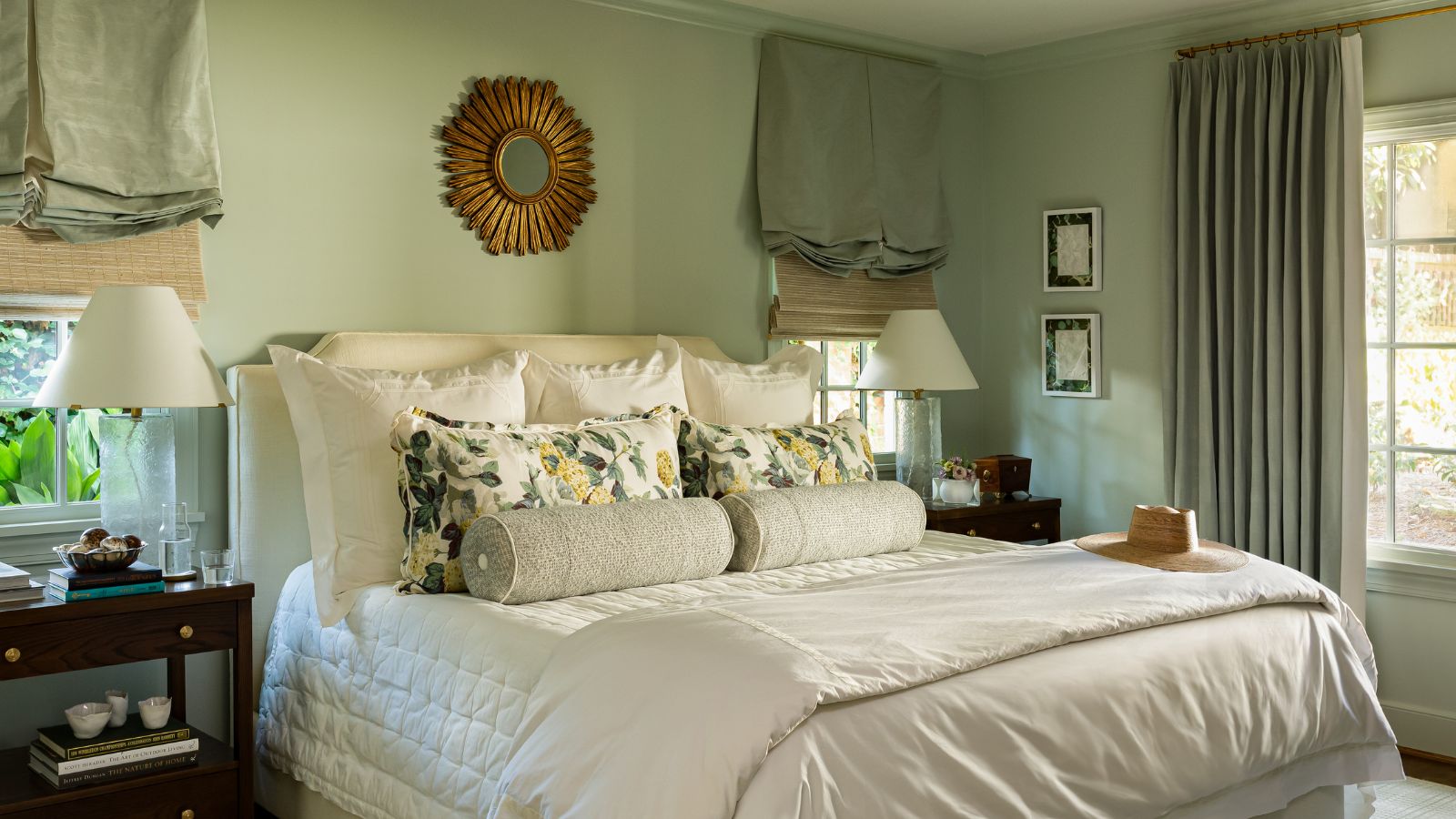 A traditional bedroom with pale green walls. 