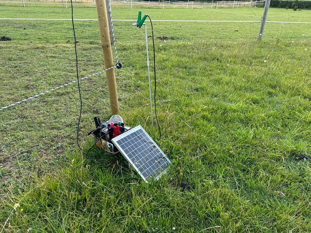 solar panel charger charging a battery in a field