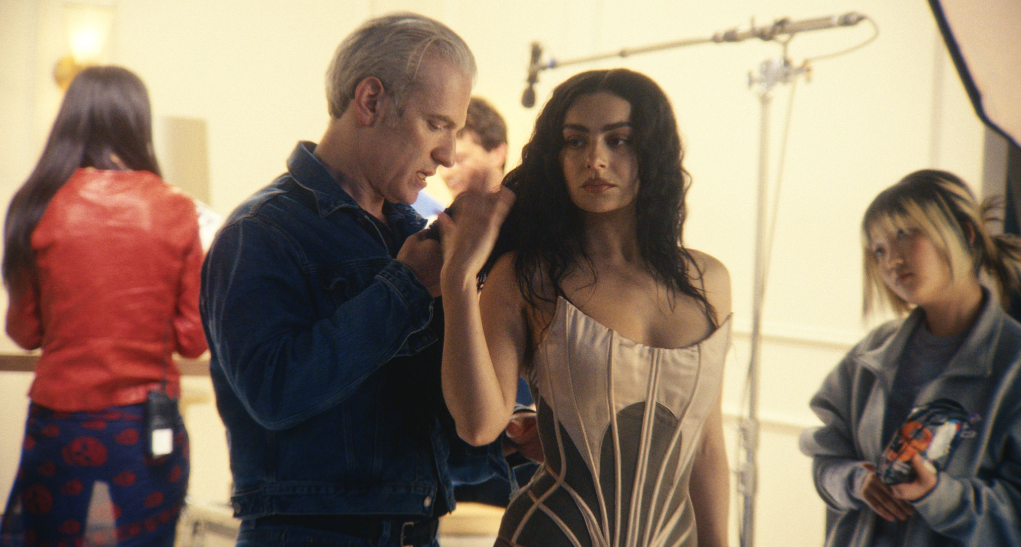 charli xcx is fitted by mel ottenberg into a baby pink tight corset in a dressing room in a still from the movie the moment