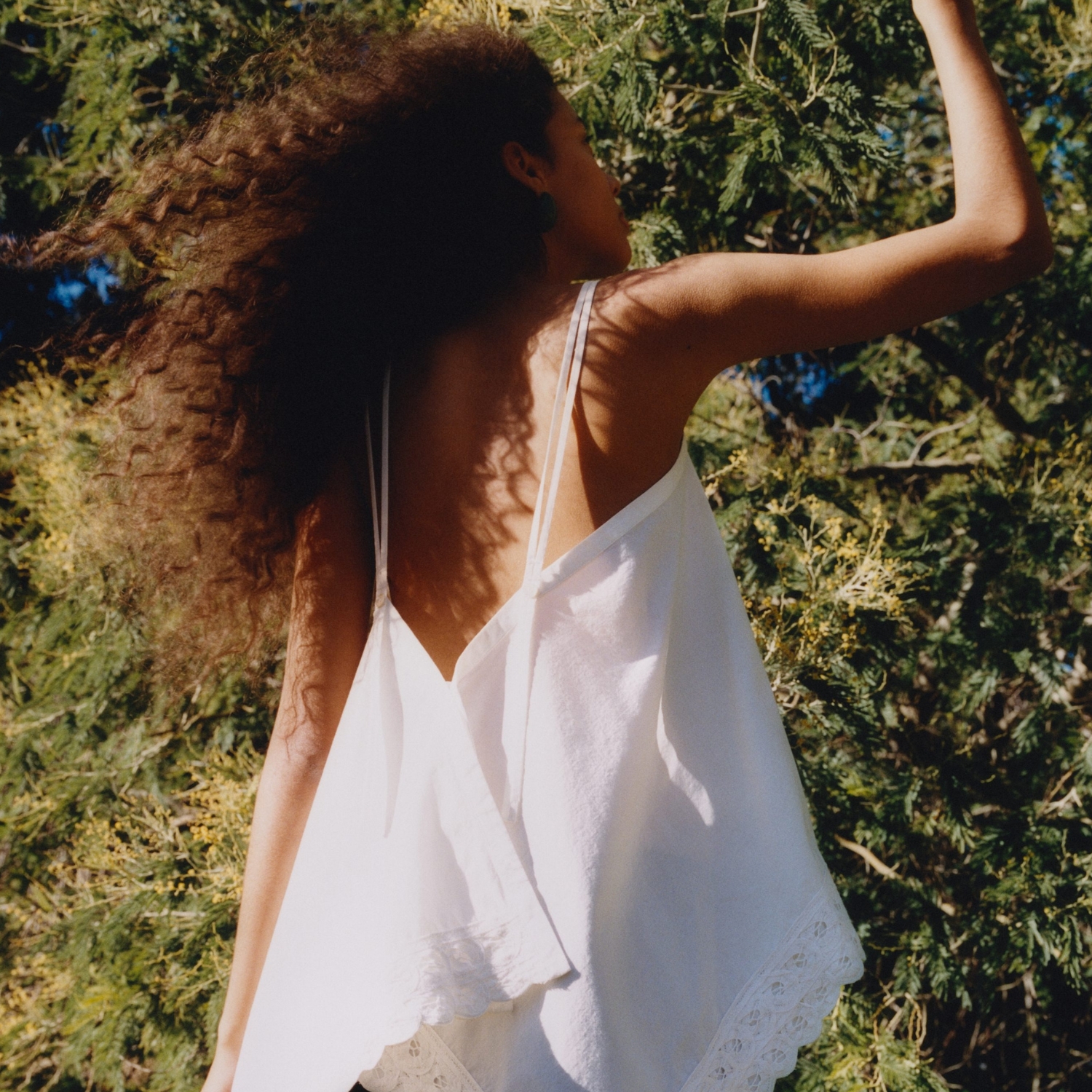 Model wearing a white ARKET cami top.