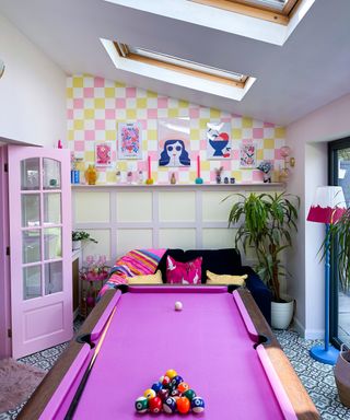 pink baise covered pool table in space with pink chequered wallpaper