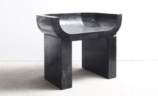 Black chair made from carved, petrified wood