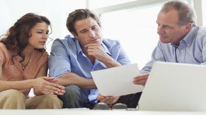 Young couple sits with older retirement planner