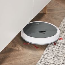 room with wooden flooring and robot vaccum cleaner