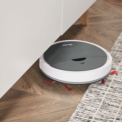 room with wooden flooring and robot vaccum cleaner