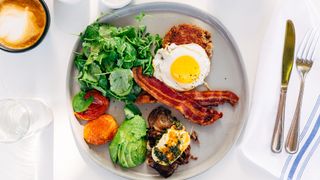 Plate of a keto diet breakfast - salad, bacon, eggs