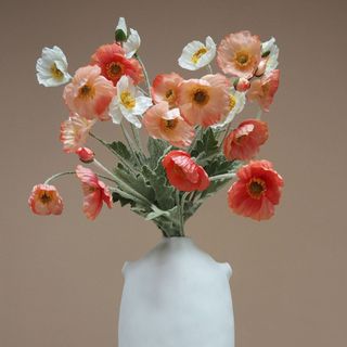 Bouquet of faux flowers in white vase