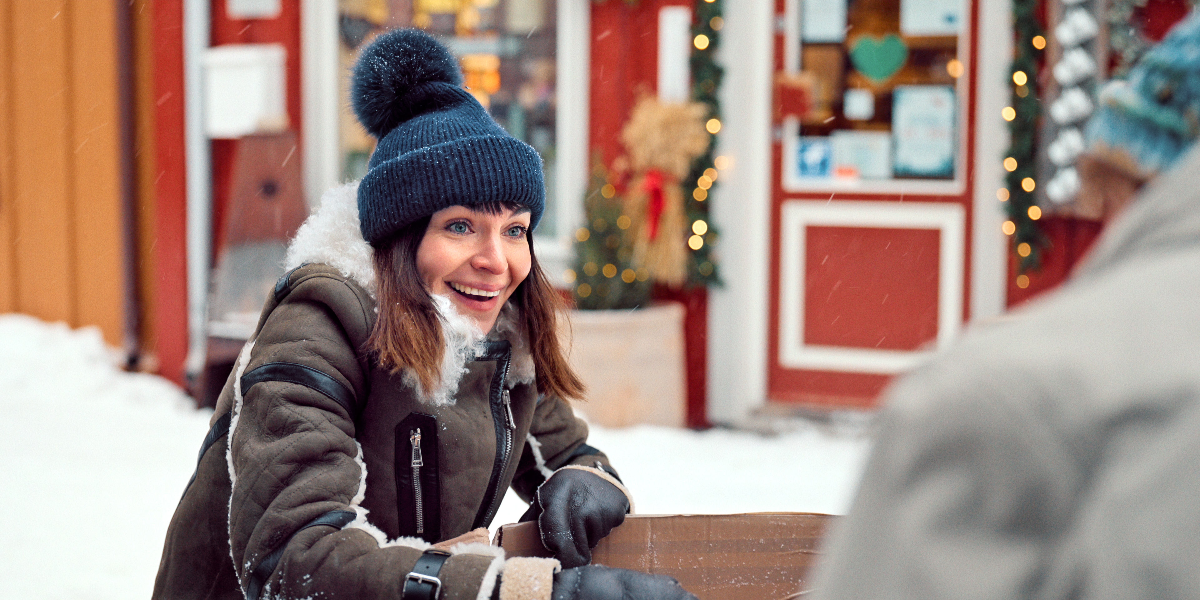 Ida Elise Broch as Johanne wearing a coat and blue hat outside in the snow in a still from Home for Christmas S3.