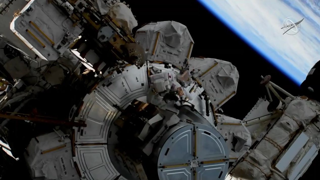 NASA astronaut Anne McClain works to clean debris outside the Unity module.