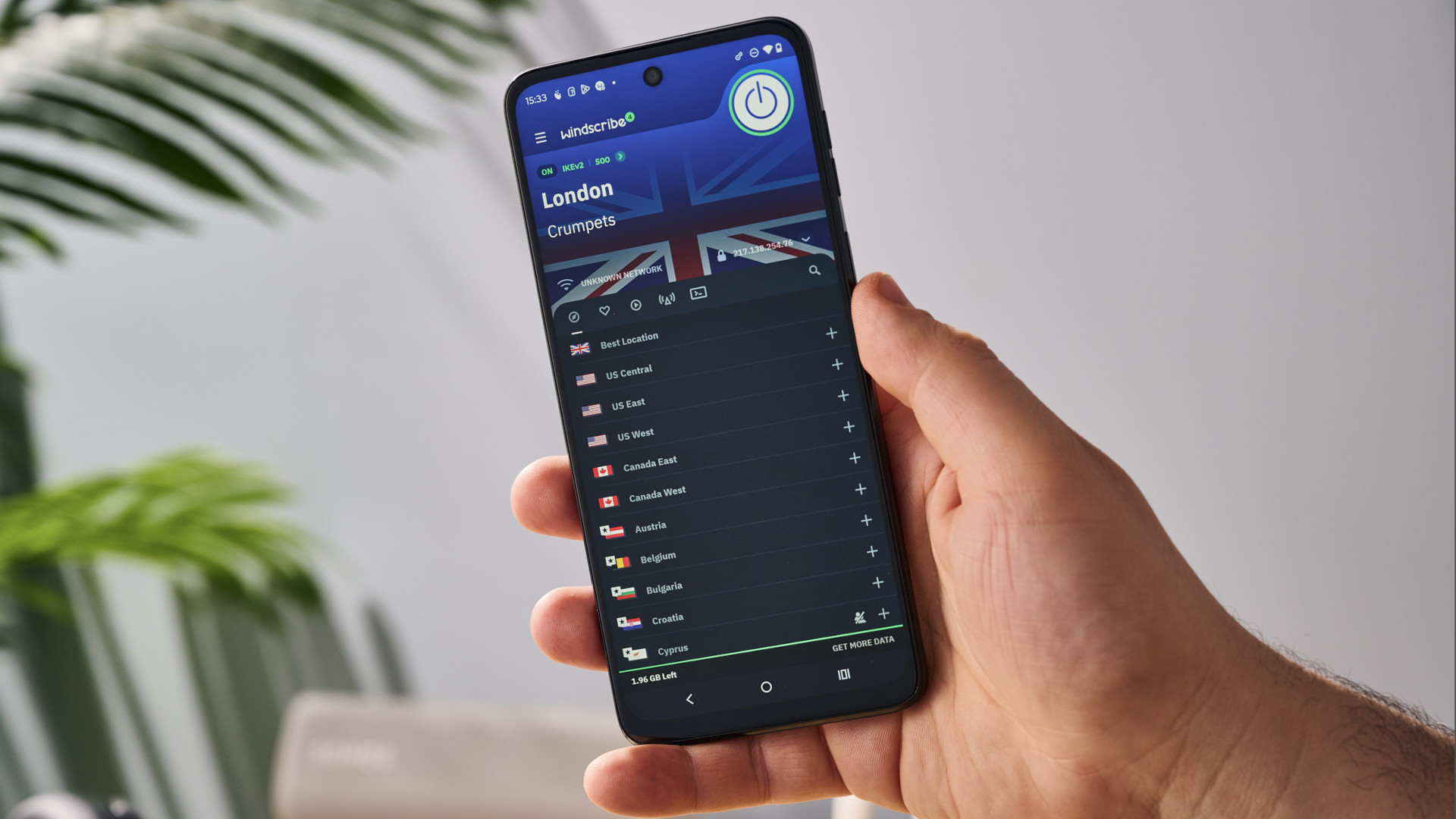 A hand holding a mobile phone running Windscribe VPN.