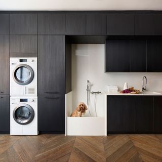 utility room with black cabinetry dog shower and parquet flooring
