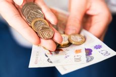 A person holds cash that they've got from pension drawdown (image: Getty Images)