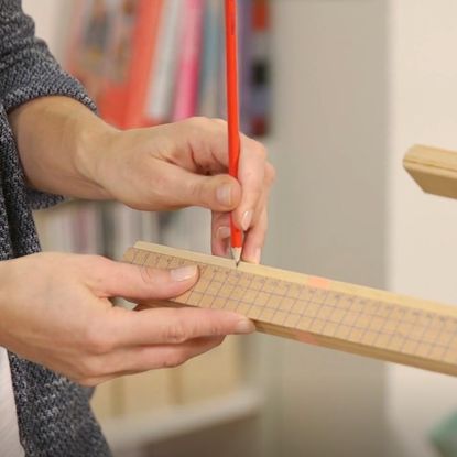 hand with pencil and wooden scale