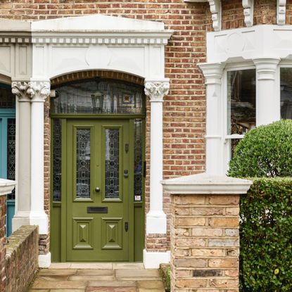 Green period front door with stained glass window design