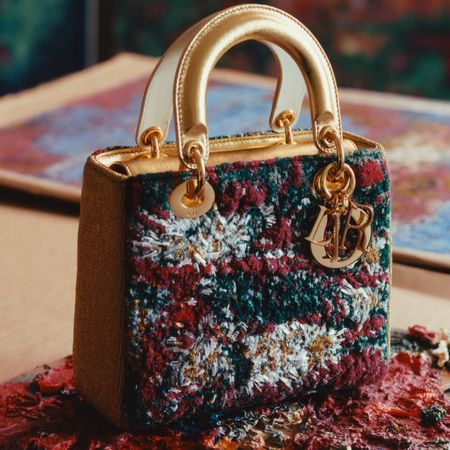 a Dior Lady Art bag next to a canvas of paint