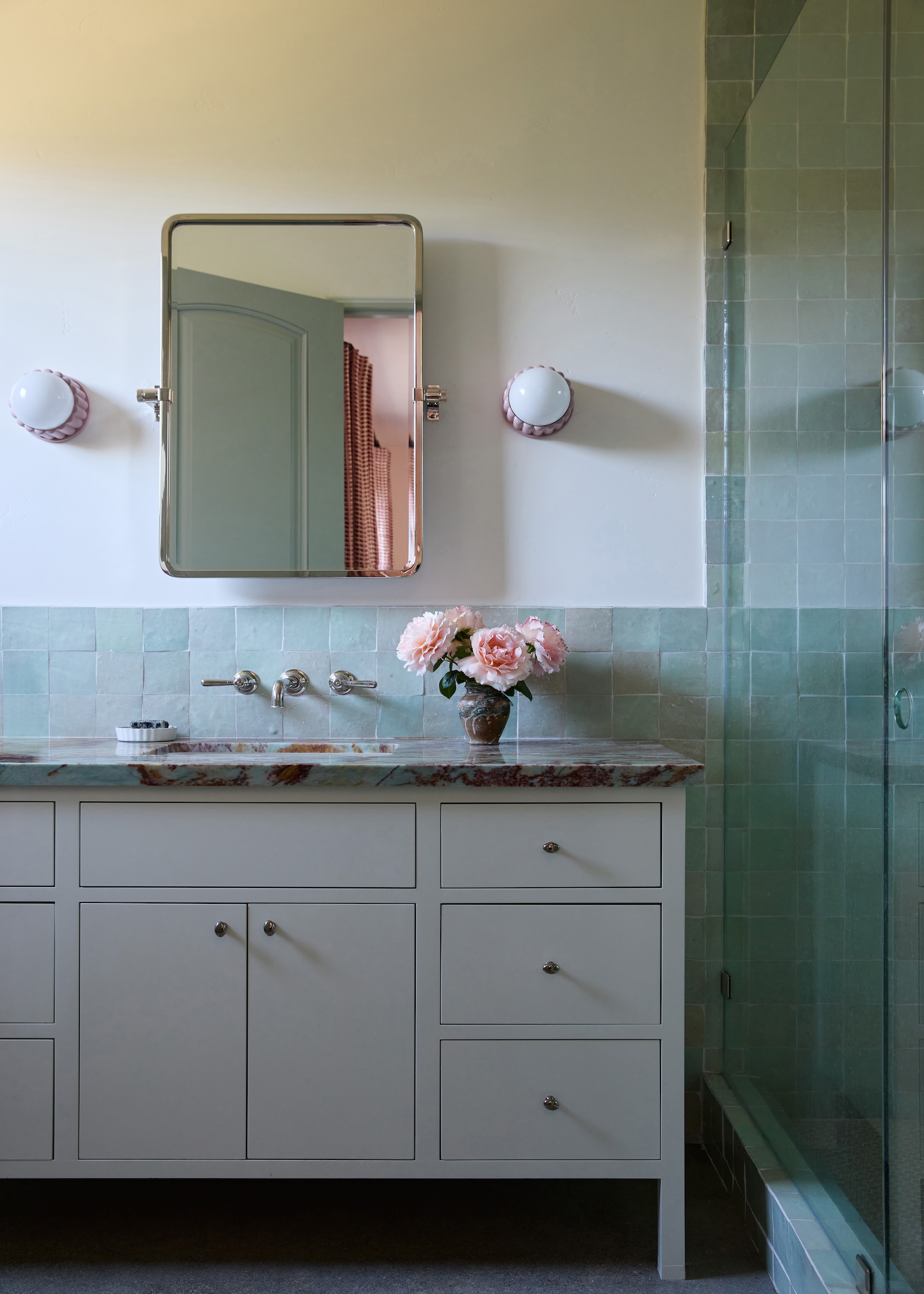 a bathroom with a grey vanity and light blue tiles