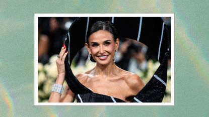 Image of Demi Moore smiling with black hair tied back in an updo and red nails, wearing black and white striped gown, on a green marbled background