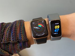 Apple Watch Series 6 next to Fitbit Charge 5
