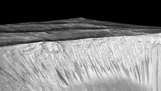 A black and white photo showing the steep walls of a crater