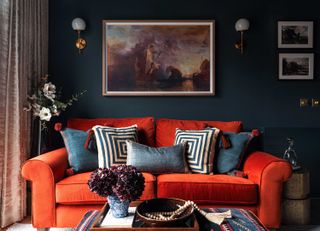 orange sofa in a dark blue living room