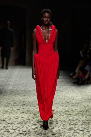 Woman in Bottega Veneta red dress on runway