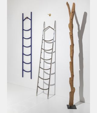 Three ladders against a white wall