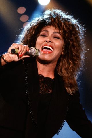 Tina Turner picture singing and wearing orange lipstick