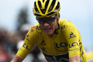 Chris Froome, wearing the overall leader's yellow jersey, injured after a fall, crosses the finish line at the end of the 19th stage