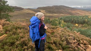 Hiker enjoying the view while wearing a blue backpack