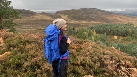 Hiker enjoying the view while wearing a blue backpack