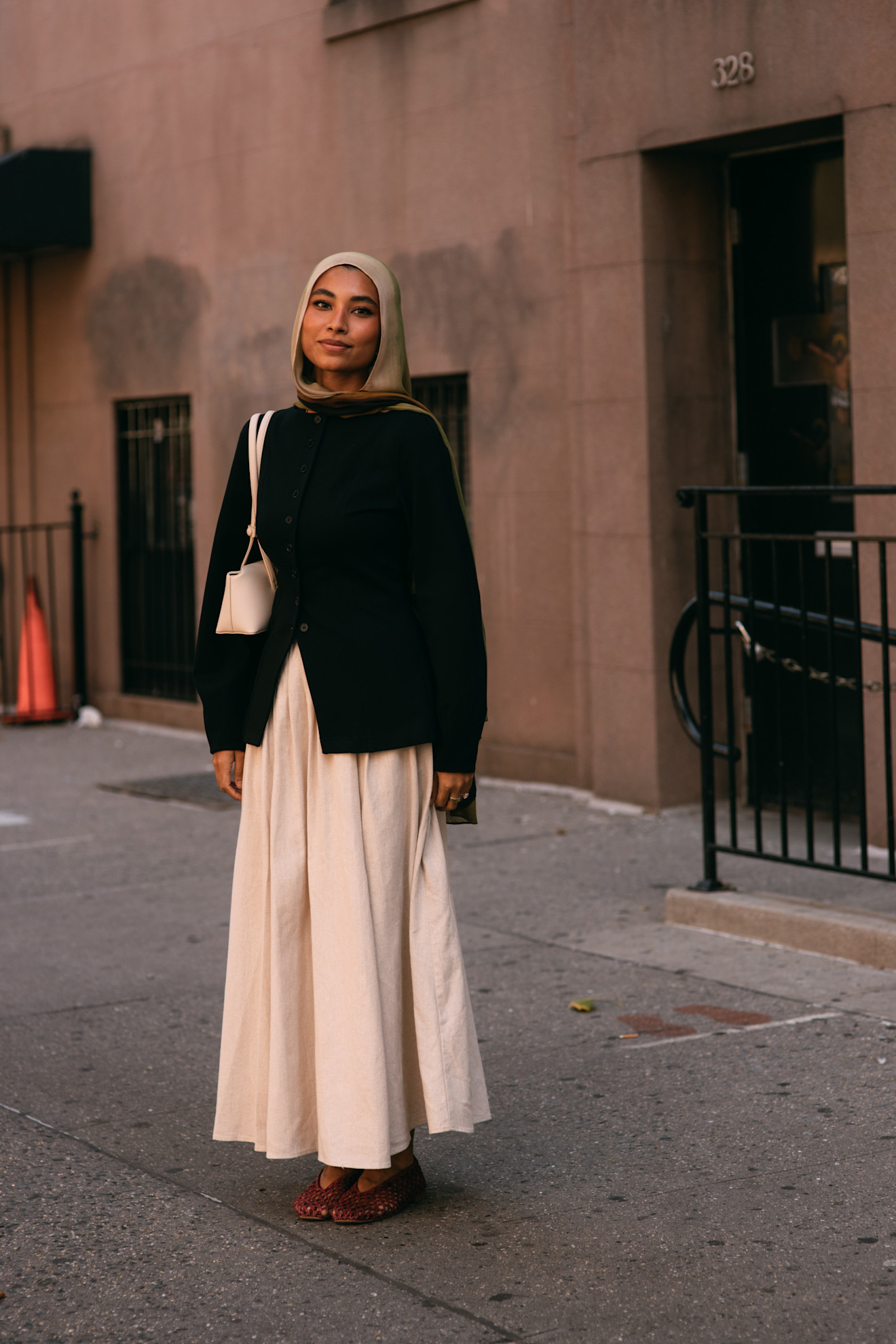 woman wearing blazer, white skirt, and white shoulder bag