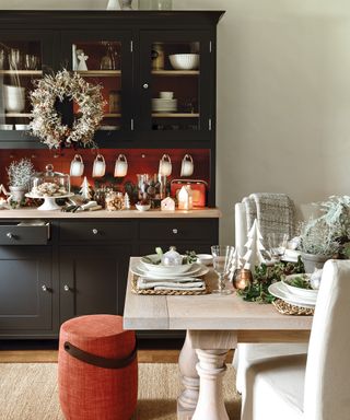 Kitchen Christmas decor ideas with a white wreath hung on black kitchen cupboards