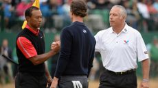 A bib-less Steve Williams shakes hands with Tiger Woods on the 18th green