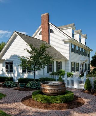 colonial style house with a white picket fence and gate