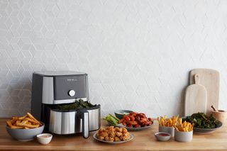 The Instant Brands air fryer surrounded by delicious air-fried food