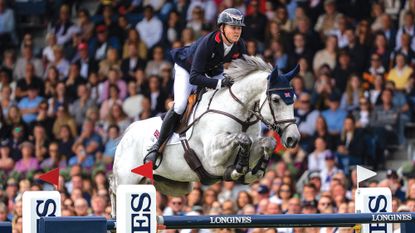 Harry Charles and LT Holst Freda clear a large Longines branded oxer in the Showjumping World Championships in Aachen 2026